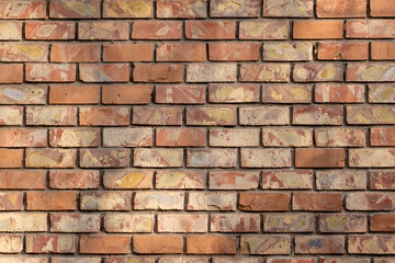 A close-up view of an old, weathered brick wall with varied shades of red, orange, and yellow bricks. The texture is rough and detailed, suitable for use as a background or texture overlay.