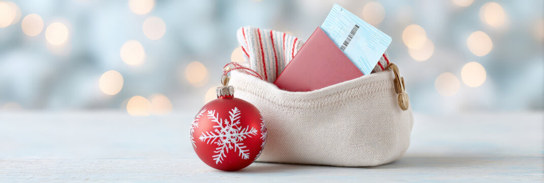Travel-themed holiday decor with red ornament and passport in festive pouch