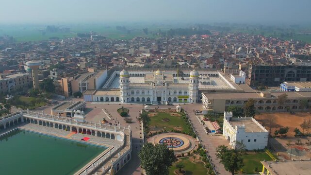 Aerial view of Gurdawara Janam Asthan with its white facade contrasting against the green gardens, Nankana Sahib, Punjab, Pakistan.