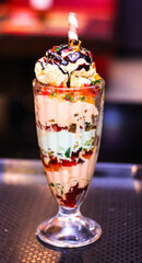 A tall glass of ice cream with a straw on top