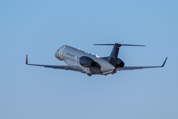 Modern luxury bizjet gains altitude in the blue sky
