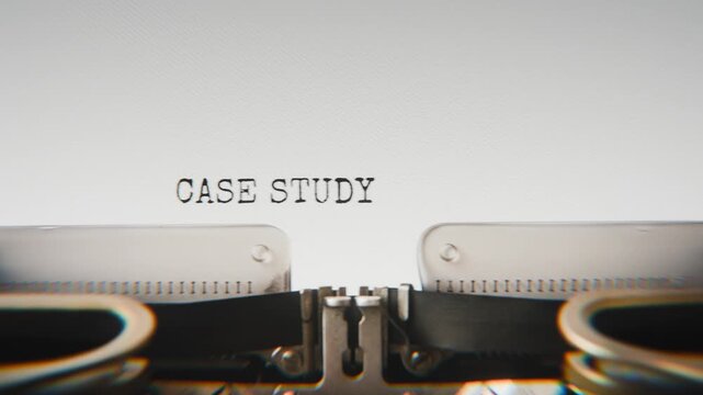 Old mechanical typewriter typing Case Study in a close-up view, with metal letters striking the white paper.
