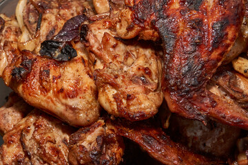 Juicy pieces of chicken were grilled in a metal grill over hot coals. The ruddy crust and smoky aroma emphasize the atmosphere of a picnic and a summer vacation in nature.