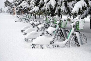 Row of bicycles covered with snow at bicycle parking