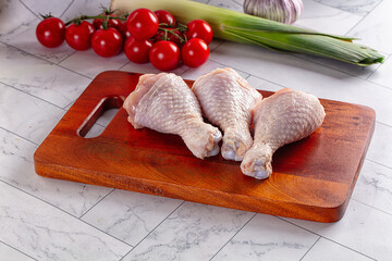 Fresh raw chicken drumsticks  over board