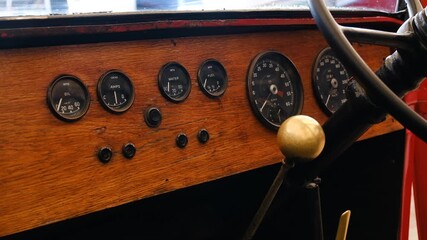 This footage features a vintage car dashboard showcasing elegant wood finish and classic gauges, exemplifying the timeless design of early automotive engineering.