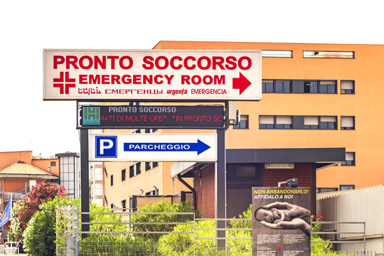 Casilino Polyclinic,hospital entrance with signs for the emergency room(Pronto Soccorso),parking directions,multilingual warnings,and public health messaging in a general hospital in Rome,Lazio,Italy.