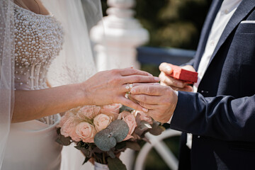 Close-up photo of the mens holding woman hand with golden wedding ring with diamond. Wedding ring...