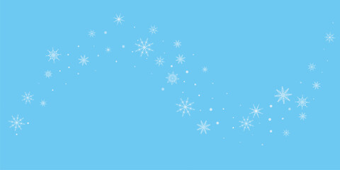 White delicate, lacy snowflakes are carried by the wind against a blue background. Christmas or New Year's background. 