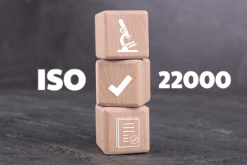 ISO 22000 Food safety management systems. Wooden cubes with different icons on grey table