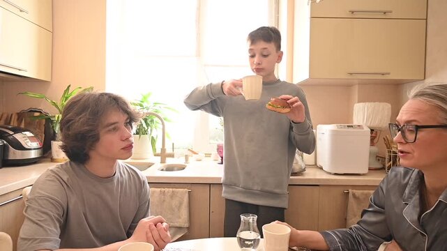 A middle-aged Caucasian woman has dinner with her two sons. 