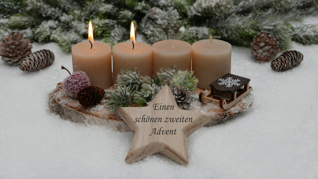 Zweiter Advent: Adventskranz mit braunen Kerzen und einem h&ouml;lzernen Stern mit der Aufschrift &bdquo;Einen sch&ouml;nen zweiten Advent&ldquo;.	