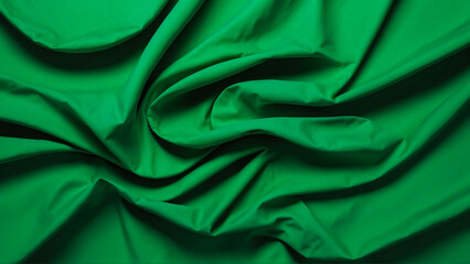 Minimalistic wavy green fabric texture, green fabric background, green silk background. All-green fabric wallpaper