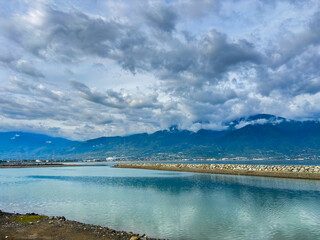 Palu city coastal landscape with dramatic clouds reflecting in calm water mountains offer a peaceful escape