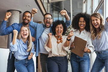 Diverse Team of Friends Celebrating Victory and Team Spirit in a Modern Office Setting