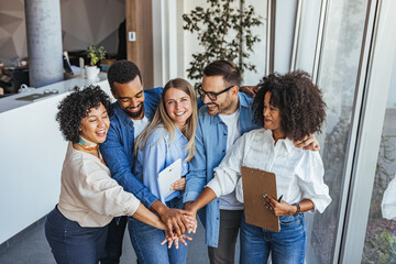 Diverse Group Of Friends And Colleagues Celebrate Teamwork In A Bright Office Setting