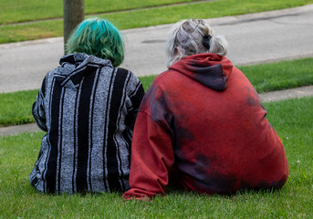 Two Teenage Girls Sitting in the Grass Hanging Out Outside