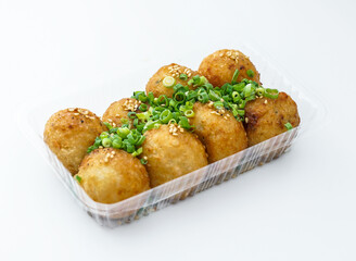 Takoyaki balls, a Japanese delicacy, ready to enjoy. These golden, savory balls are garnished with fresh green onions and sesame seeds.