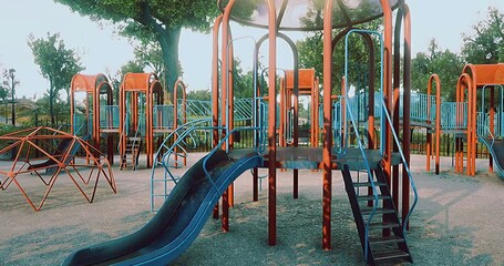 Brightly colored playground equipment stands ready for children’s laughter and fun. The vibrant slides and climbing structures shine under a clear blue sky in a lively park setting. - Powered by Adobe