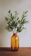 Decorative Olive Branches in an Amber Vase on a Wooden Table in a Serene Indoor Space