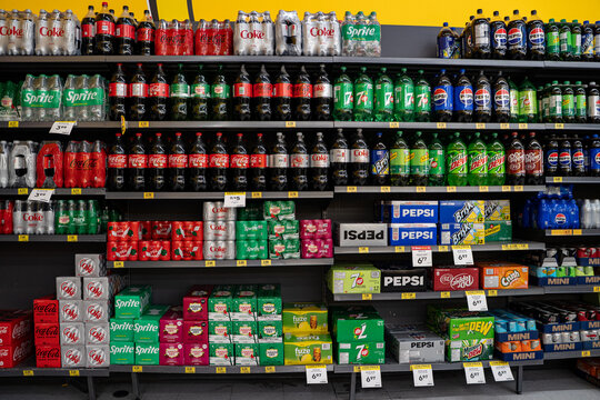 Assorted soda bottles and cans displayed on grocery store shelf. Brampton, Canada - November 16, 2025.