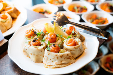 A variety of fresh dishes displayed on a buffet table at a catered event, featuring salads, appetizers, and hot meals arranged in a professional food service setup