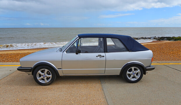 Classic  Silver Volkswagen Golf Mk1 Cabriolet. VW parked on seafront promenade beach and sea in background
