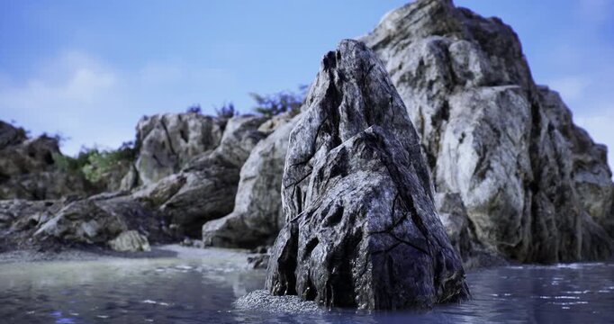 A colossal rock formation rises from the calm ocean waters, shimmering in the early morning light. The clear blue sky complements the serene beach, creating a peaceful and stunning vista.