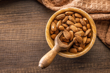 Almond kernel nuts in bowl on wooden table. Top view.