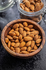 Almond kernel nuts in bowl on black table.