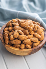 Almond kernel nuts in bowl on white table.