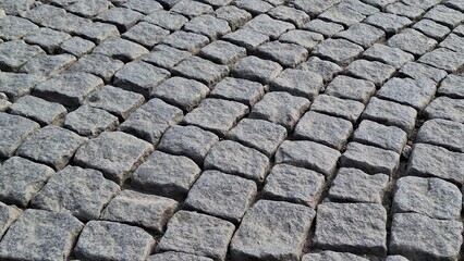 Detailed texture of an old, uneven cobblestone street or pavement. Historical architecture, travel, and rough background surface