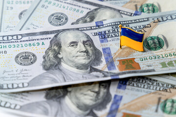 Hundred dollar bills are scattered on the table. National flag of Ukraine on the dollars. Financial political scandal in Ukraine.