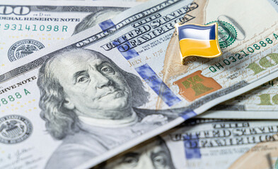 Hundred dollar bills are scattered on the table. National flag of Ukraine on the dollars. Financial political scandal in Ukraine.