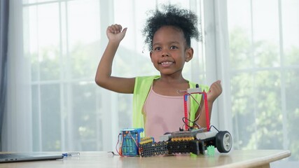 Young African girl engineer working on robotics project in a STEM education class. child is focused on assembling and learning about a small robot or electronic project. innovation, technology. - Powered by Adobe