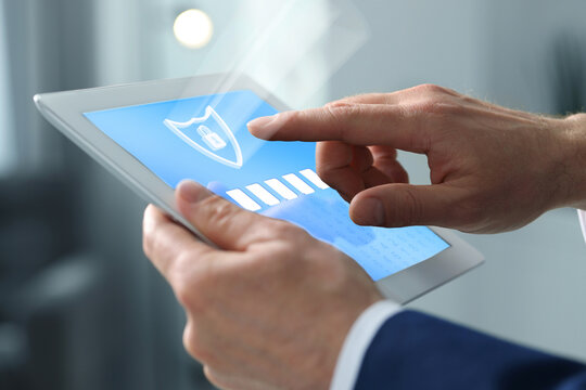 Cyber security and data protection concept. Man unlocking tablet computer, closeup. Password box and shield illustration on device screen