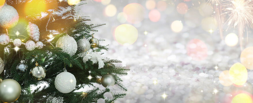 Merry Christmas and Happy Holidays. Fir tree with festive ornaments and bokeh lights on card