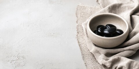 Simple bowl of black stones on a rustic table setting