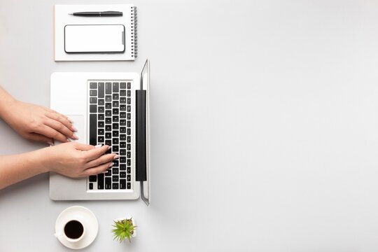 Woman Typing on Laptop with Coffee and Plant - Powered by Adobe