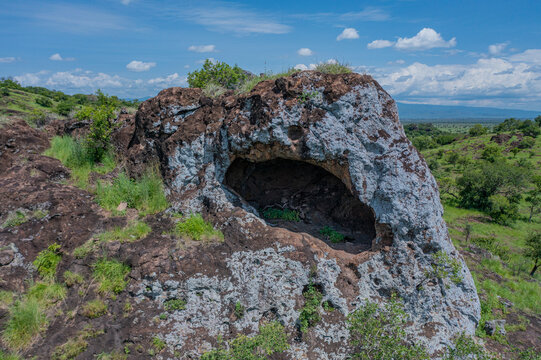 Aerial view of the Napedet cave, its textured surface contrasting with the vibrant green vegetation, a hidden cave offering a glimpse into the landscape, Pian Upe Game Reserve, Moroto, Uganda.