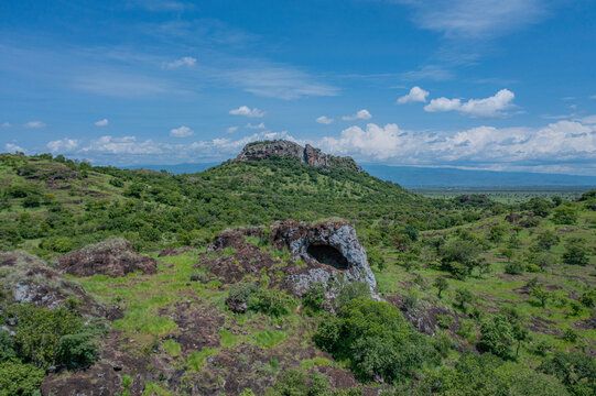 Aerial view of the Napedet cave under a vast blue sky, Pian Upe Game Reserve, Moroto, Uganda.