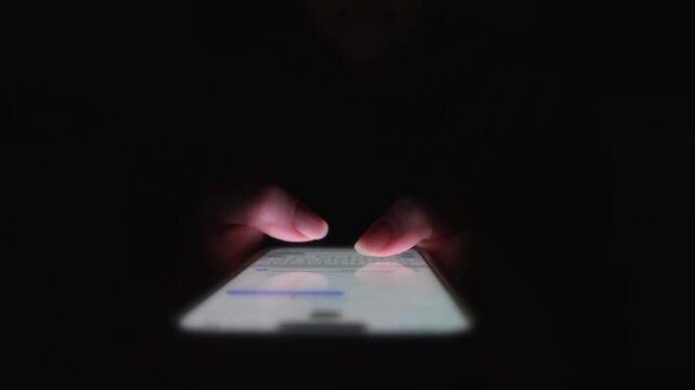 Cyberbullying at Night with Close-Up Hands Typing on a Smartphone Screen. A moment of digital hostility and trolling captured in a tense and moody cyber setting