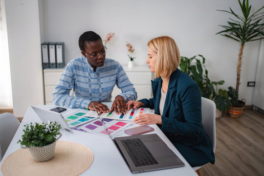 Diverse colleagues discussing color palettes for creative design project - Powered by Adobe