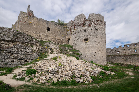 View of the crumbling stone walls of Plavecky hrad castle rise against a cloudy sky, ruins scattered below, Plavecke Podhradie, Bratislava Region, Slovakia.