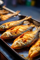 Fototapeta premium A close-up of Moyo (fried fish), golden and crispy, often served with chili sauce or fresh vegetables, a common street food.
