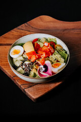 Colorful salad bowl with fresh ingredients served on a wooden surface