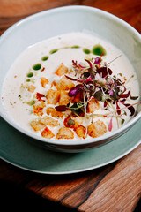 Delicious creamy soup with croutons and herbs served in a stylish bowl
