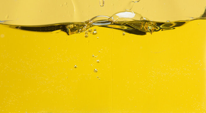 Side cut image of oil with bubbles and waves in a container