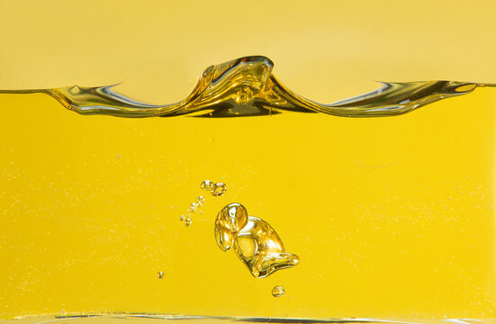 Side cut image of oil with bubbles and waves in a container