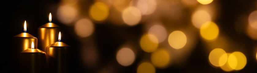 candles burning against holiday lights background
